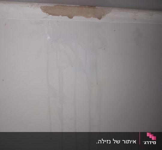 כתם רטיבות על קיר עם סימני נזילה